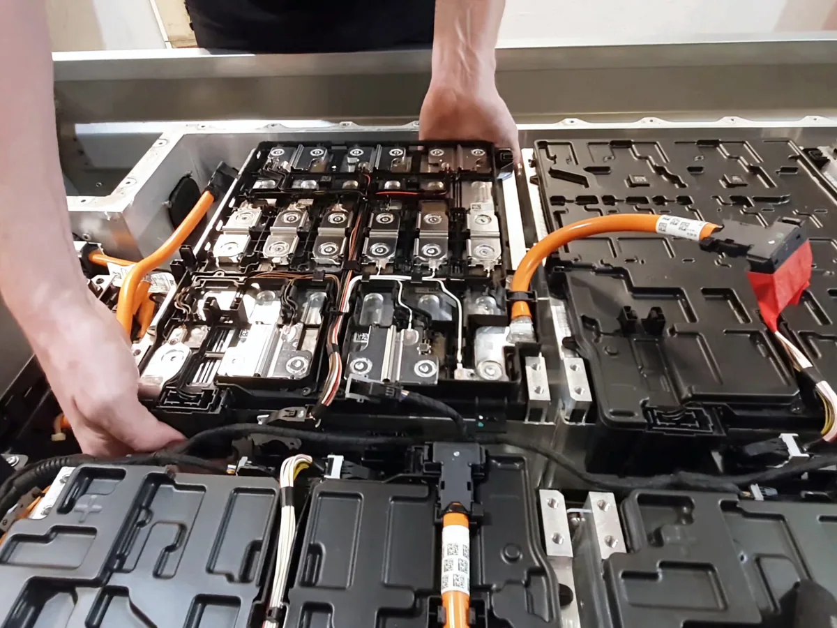 EV battery pack opened up during assembly, showing the cell modules and high-voltage wiring