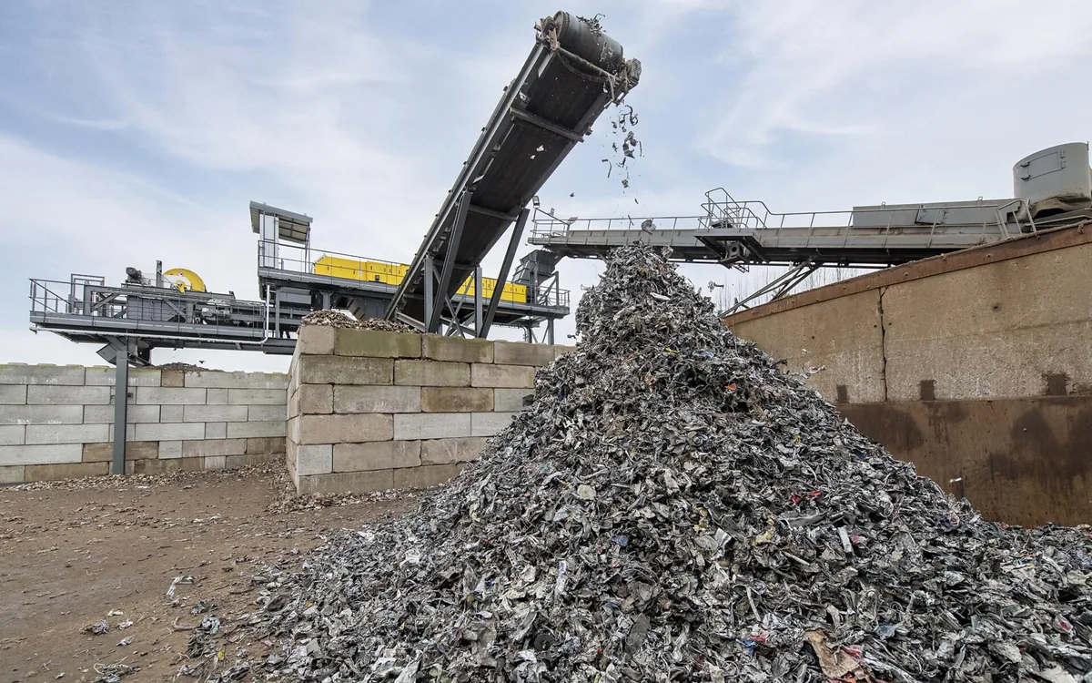 Shredded metal scrap discharging from a conveyor onto a stockpile