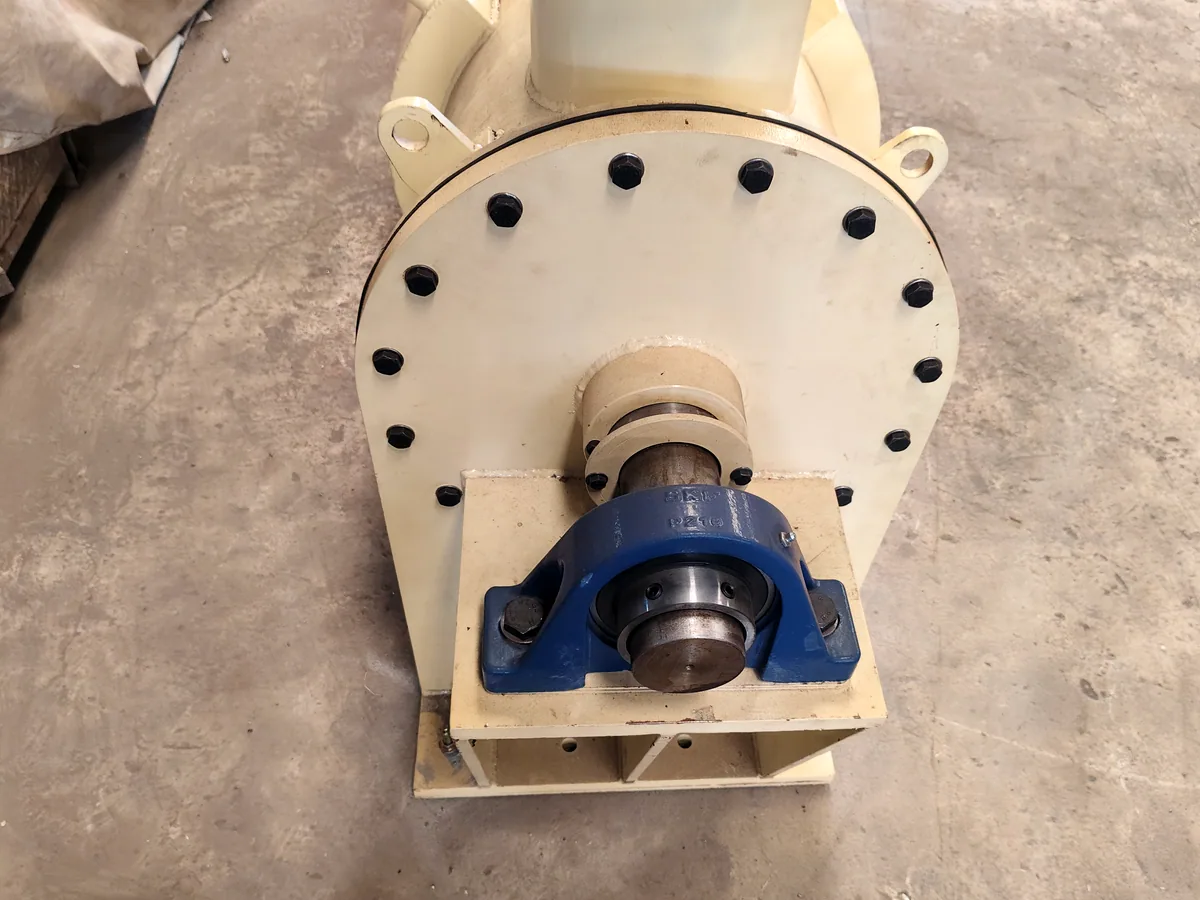 Bolted end flange and trunnion shaft of a ball mill carried in a cast pillow-block bearing