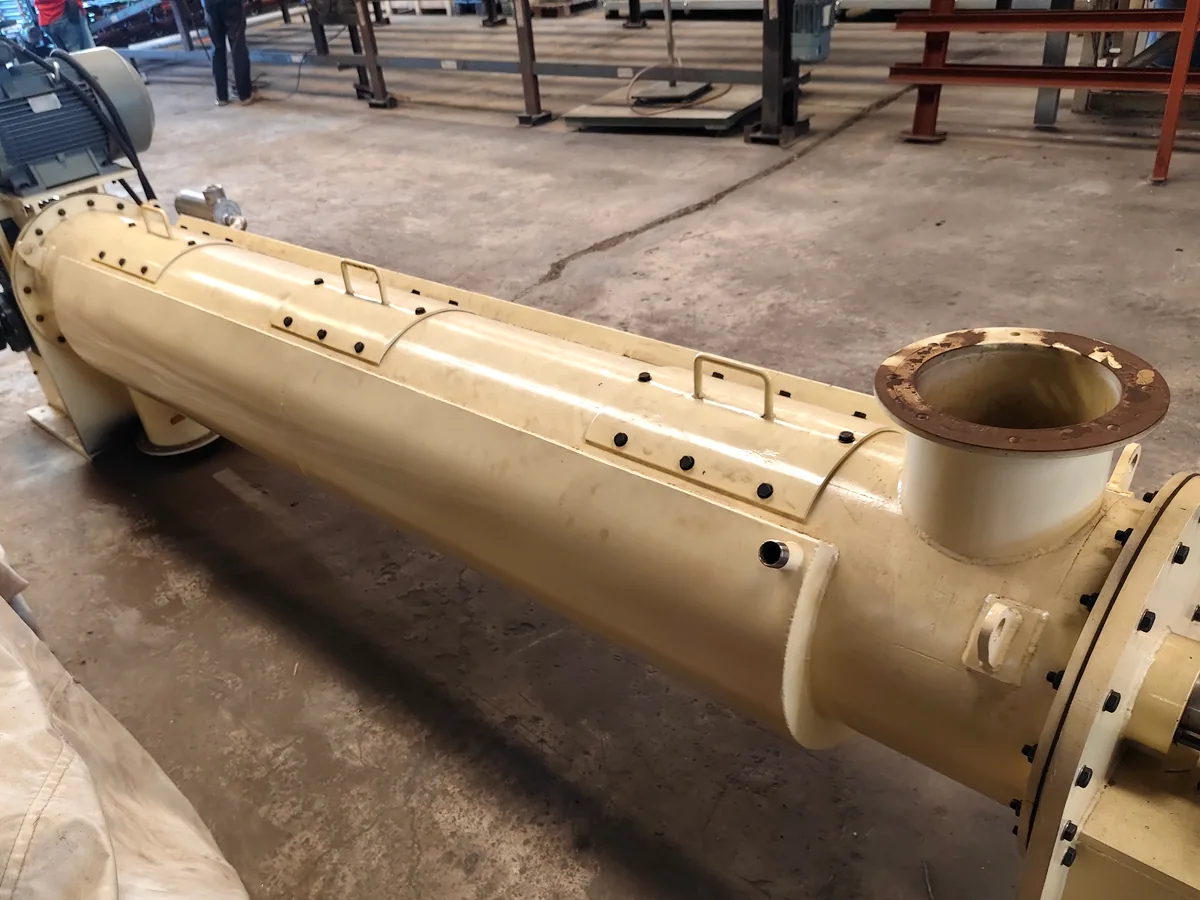 Full length of a ball mill shell showing the charging port, discharge flange and inspection covers