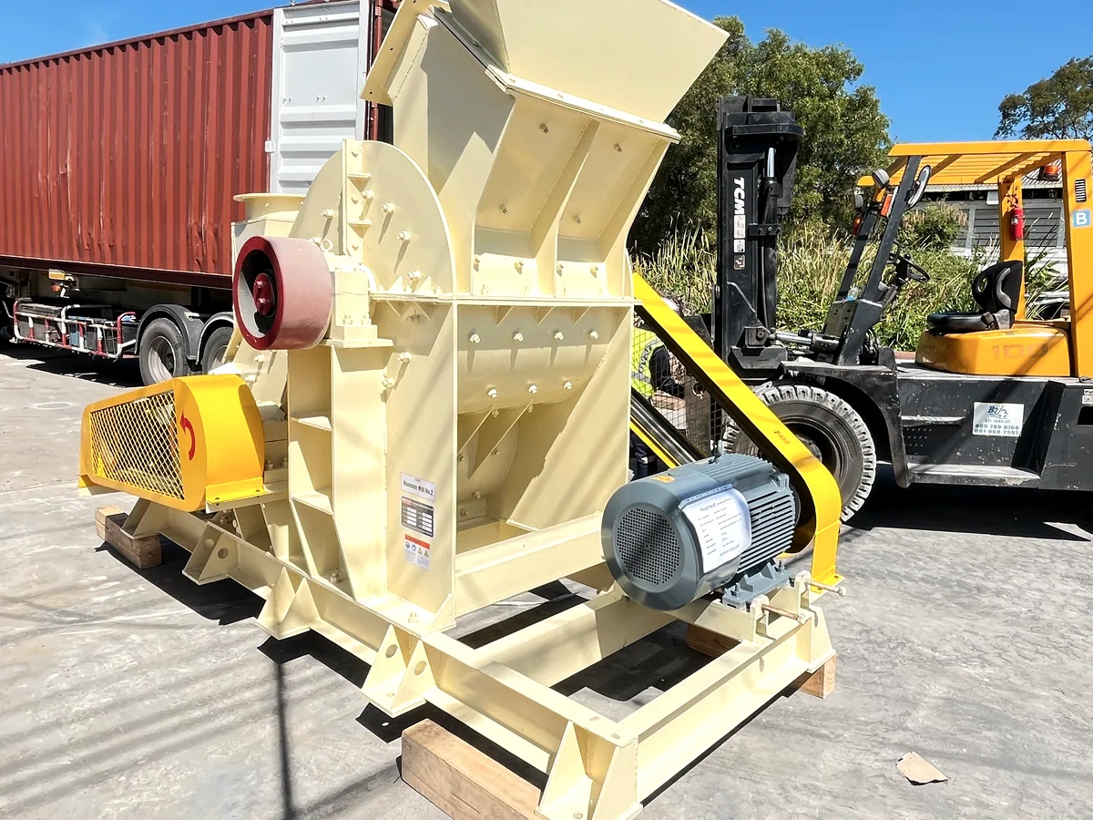 Completed hammer mill beside a forklift and shipping container before export loading