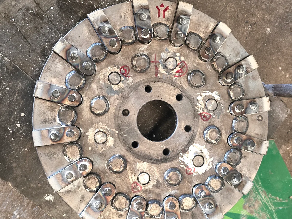 Rotor pin disc removed from a pin mill, its concentric rows of hardened pins facing up